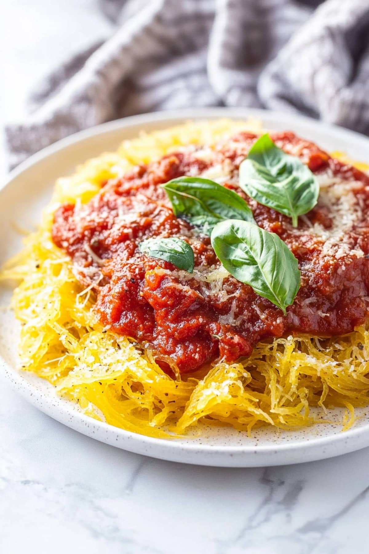 A close-up shot of spaghetti squash with marinara sauce.