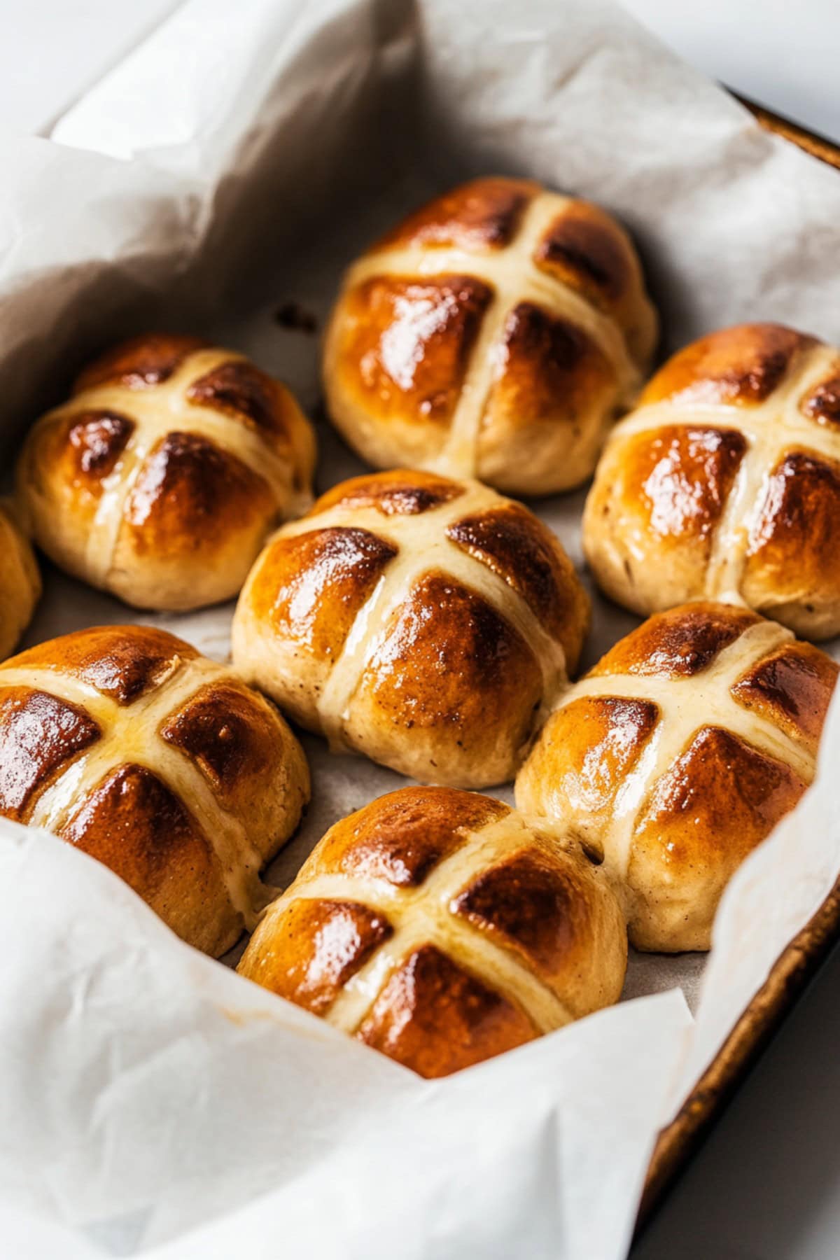 A baking pan filled with warm hot cross buns