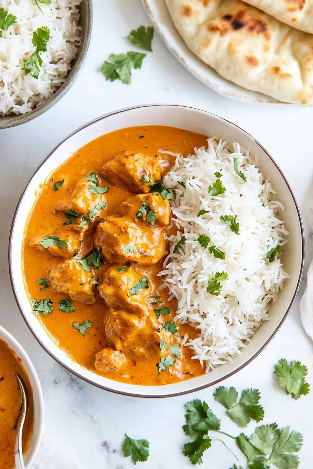 Indian butter chicken with basmati rice in a bowl.