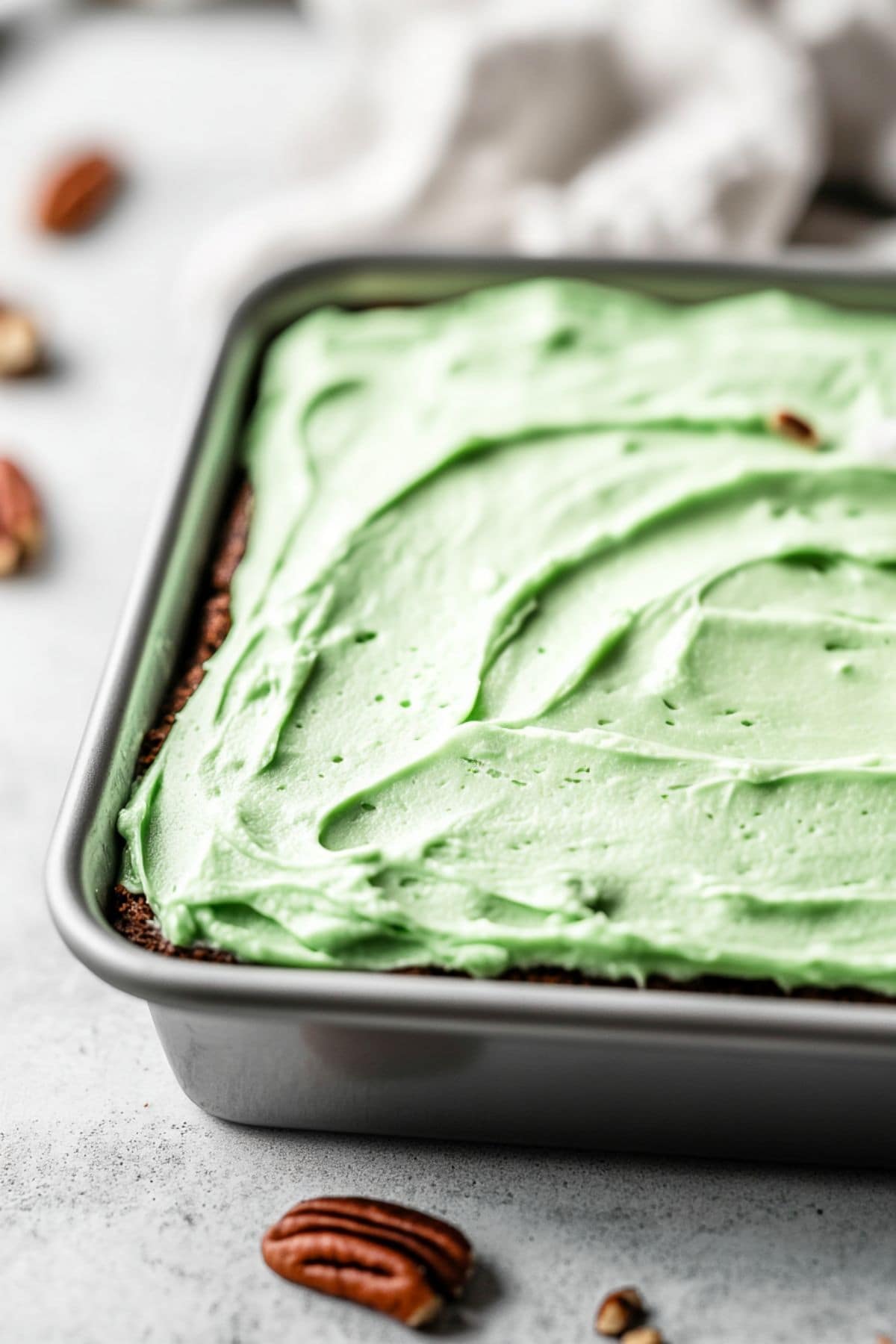 Cake in a baking pan topped with green frosting.