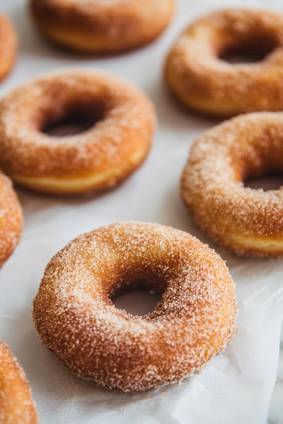 Freshly baked apple cider donuts on a parchment  paper, close up