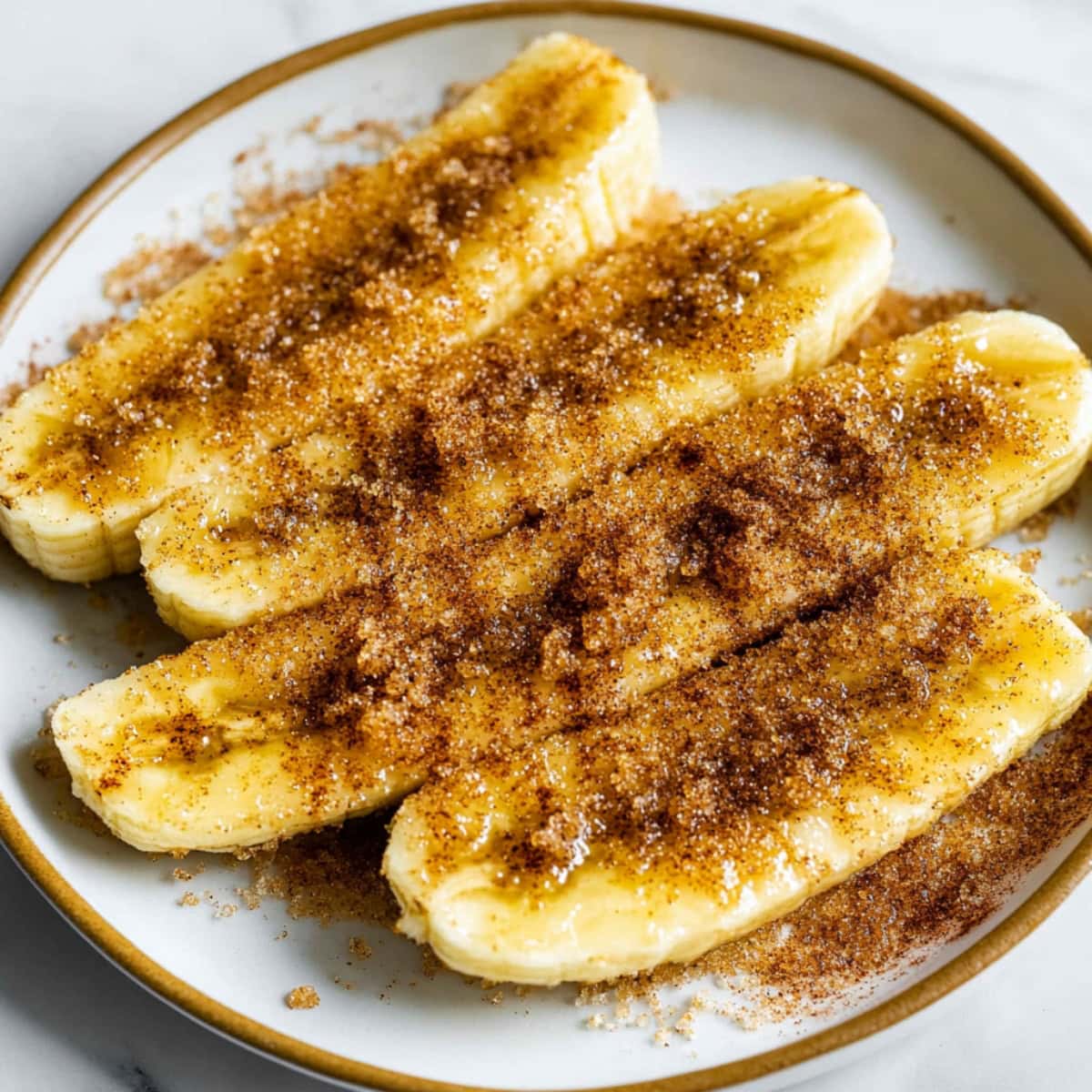 Banana slices covered in cinnamon sugar on a plate.