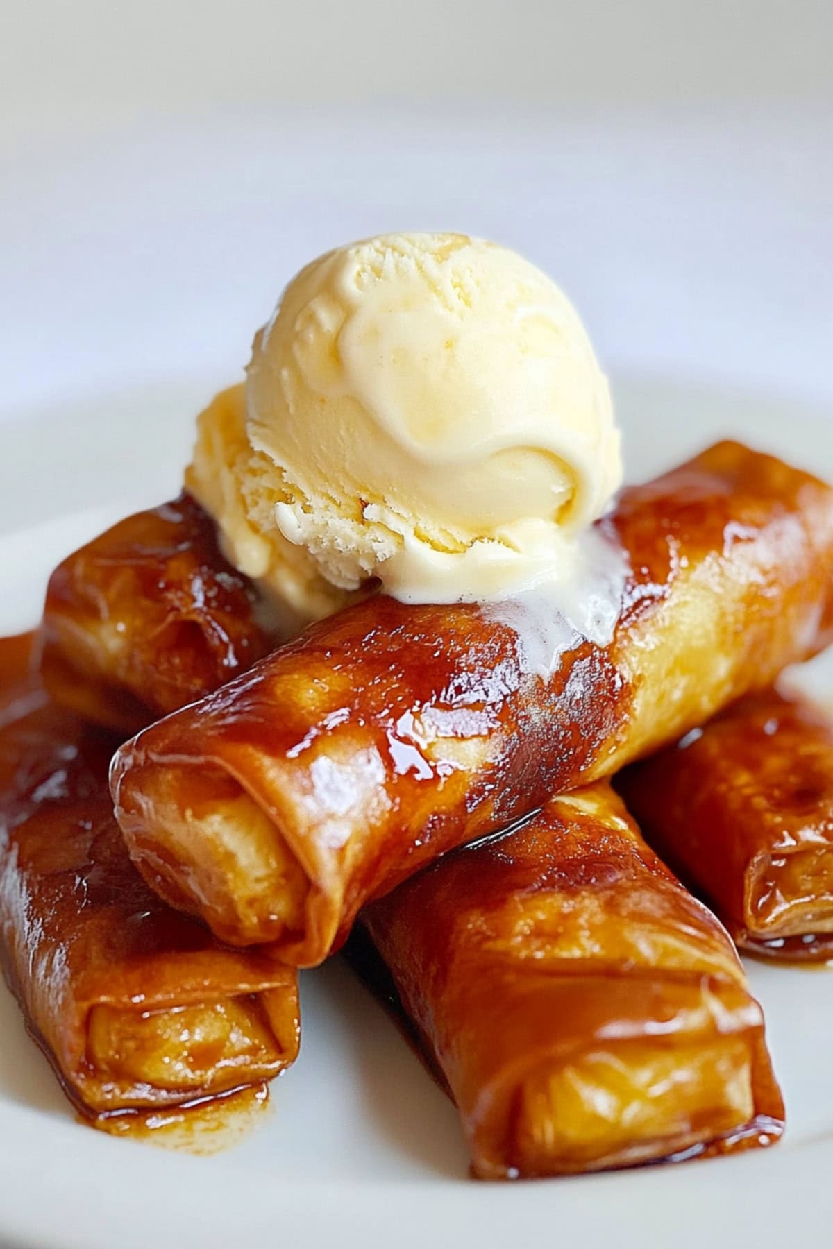 Sweet and crispy homemade banana lumpia (Turon) served with a scoop of vanilla ice cream on top