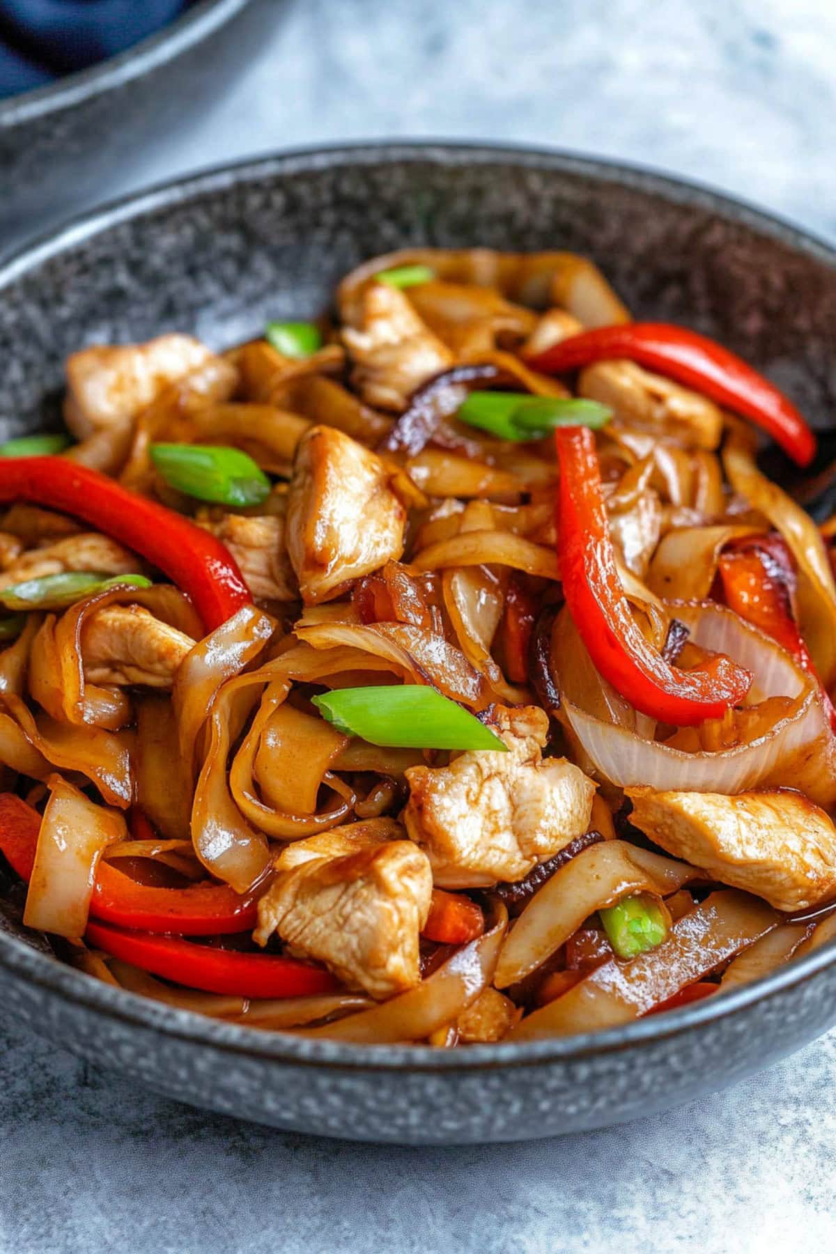 Chicken chow fun with bell peppers, green and white onions.