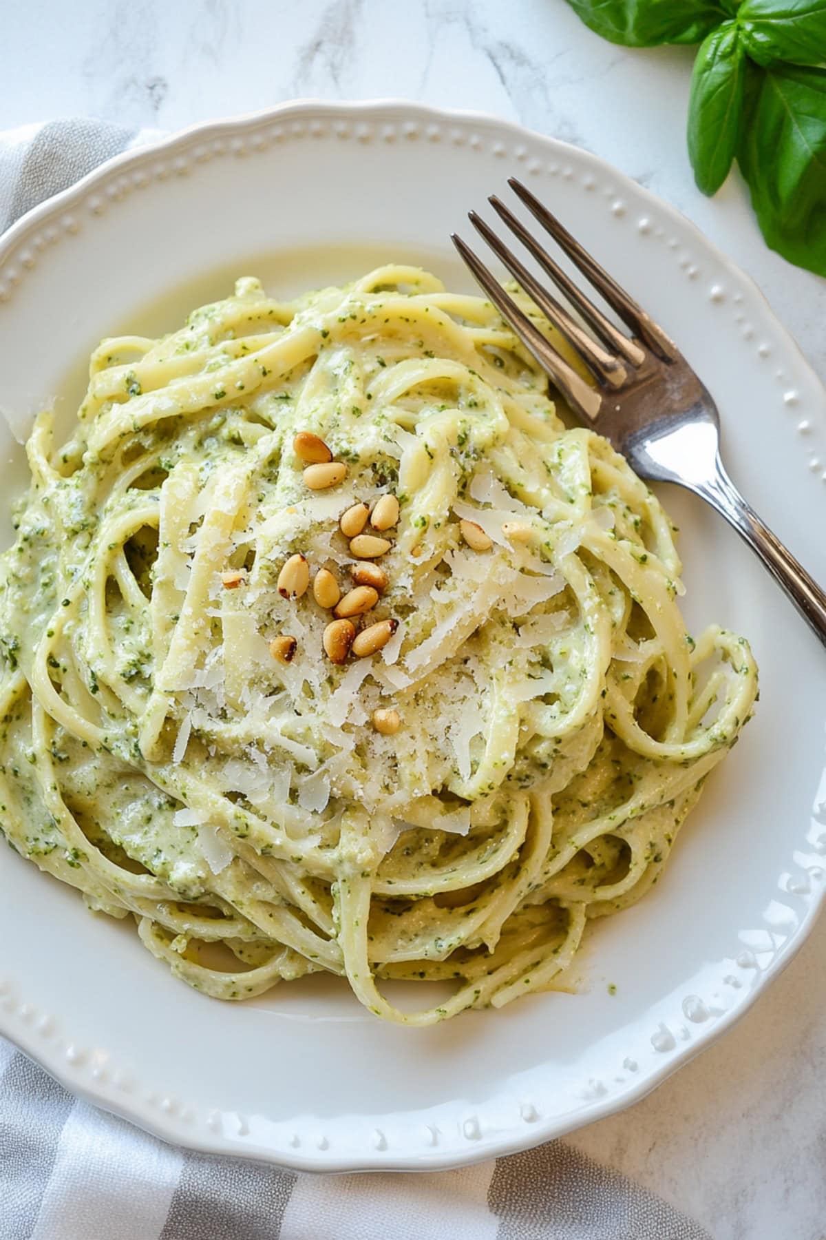 Rich and velvety lemon pesto pasta on a plate, top view.