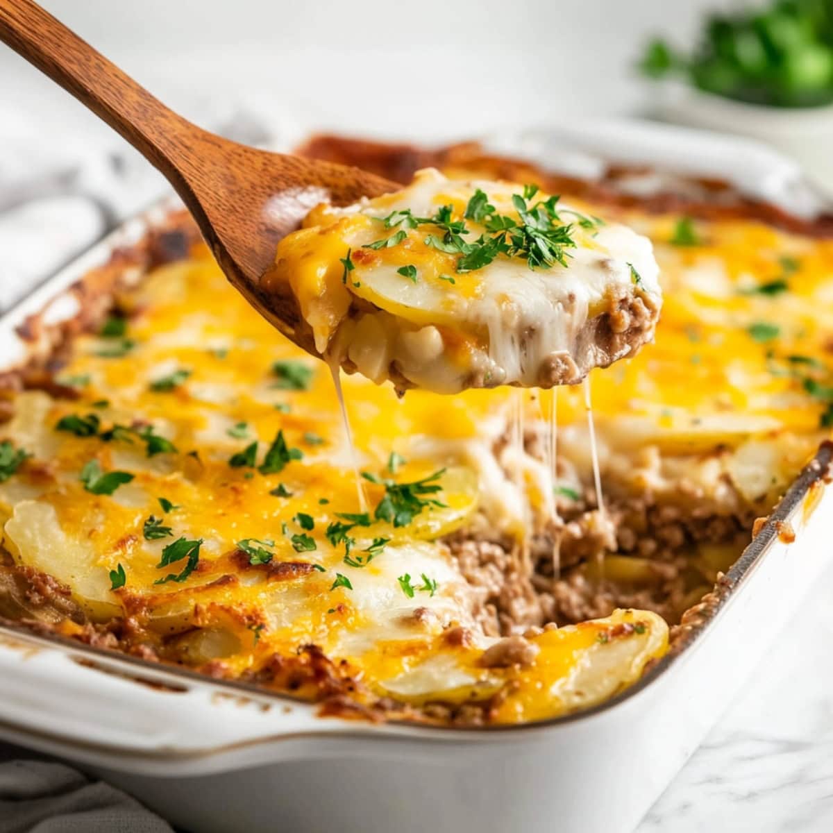 A hearty hamburger potato casserole with layers of ground beef, sliced potatoes, and melted cheese on top.