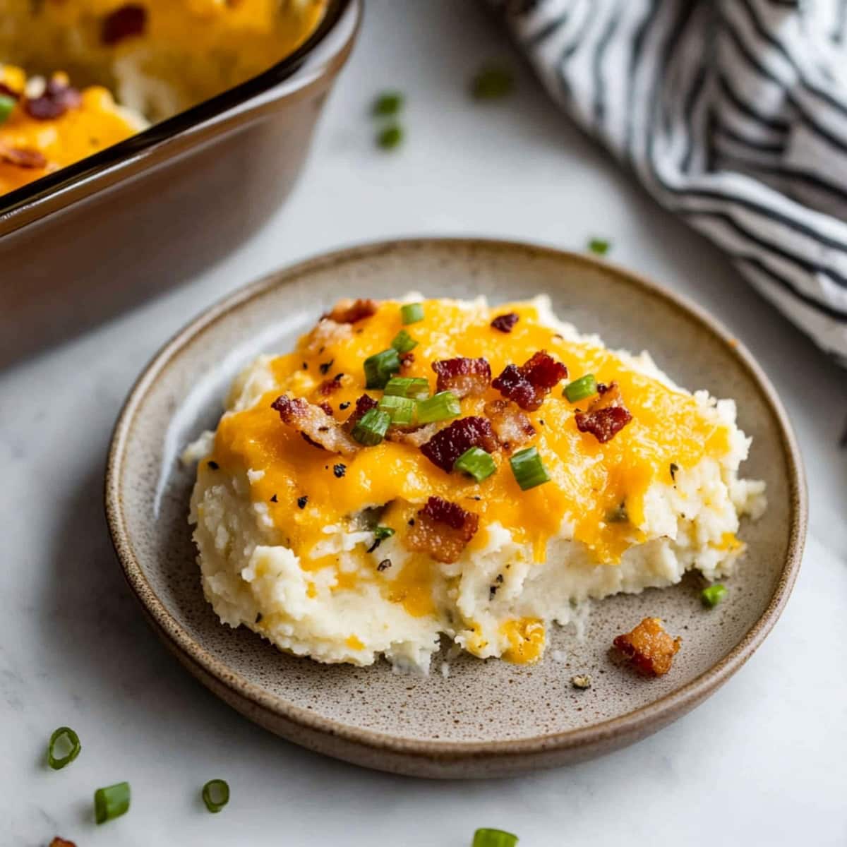 A slice of loaded baked potato casserole served on a plate