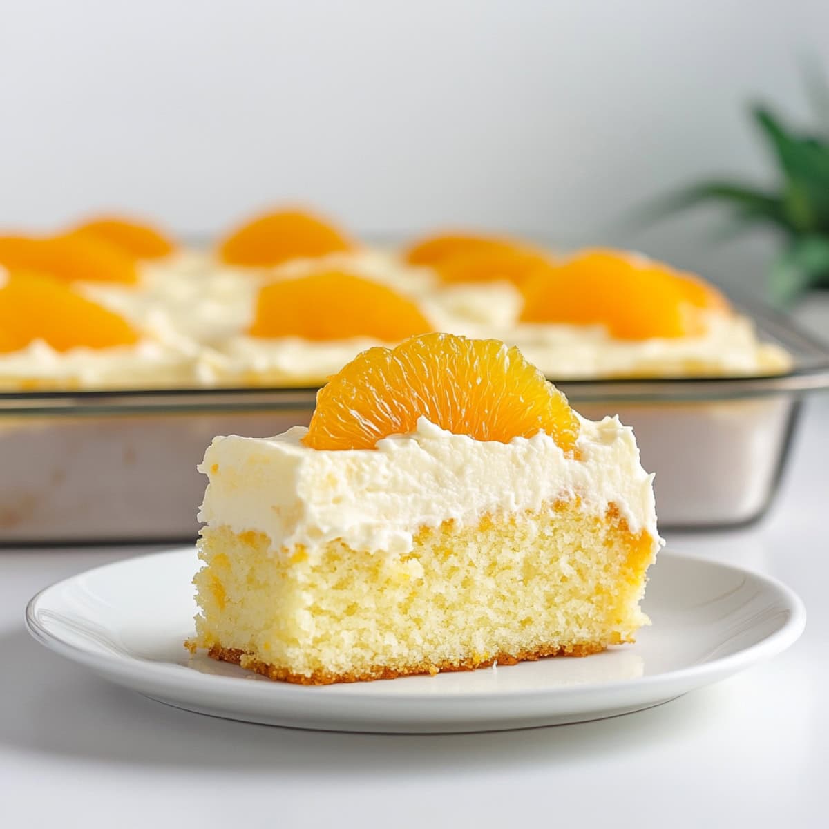 Slice of cake with white frosting and orange on top.