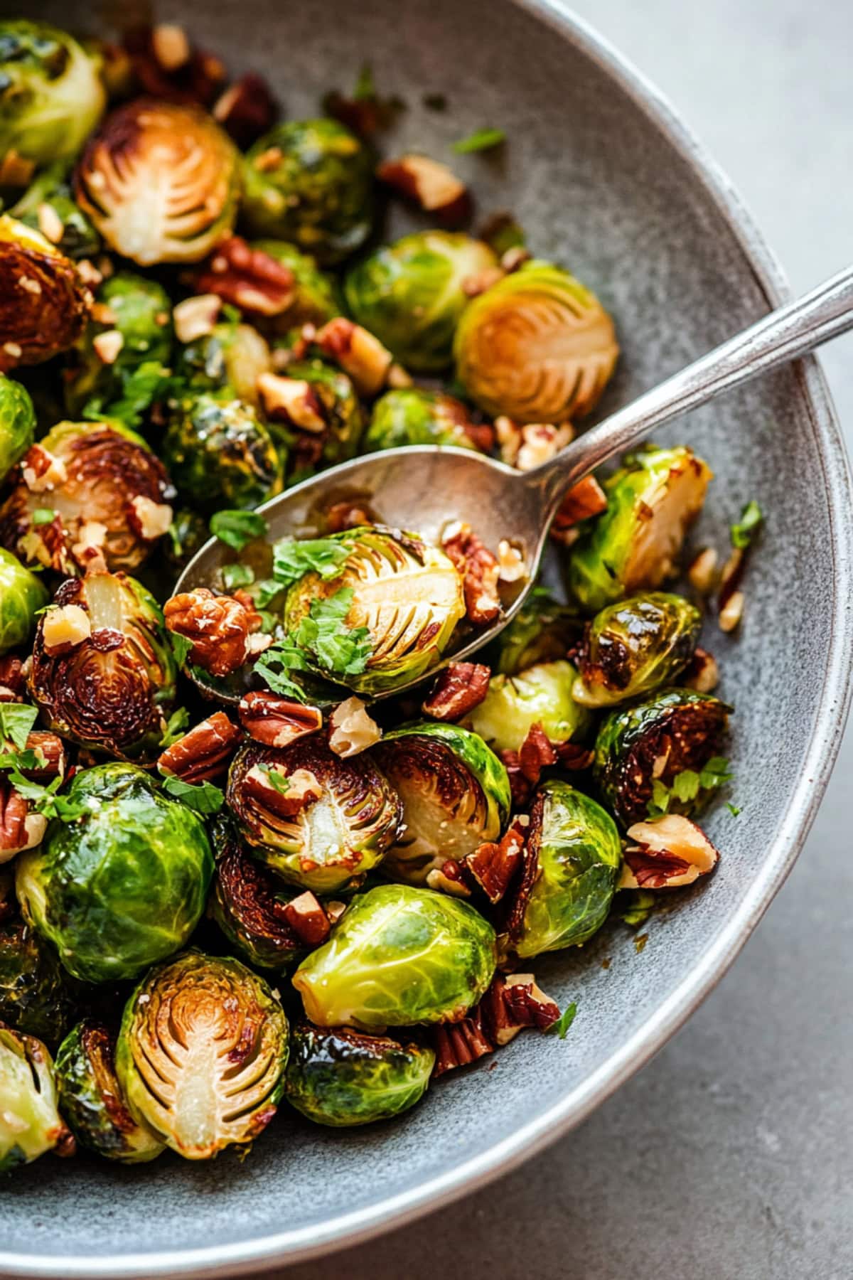 A bowl of homemade maple glazed brussels sprouts with chopped pecans.