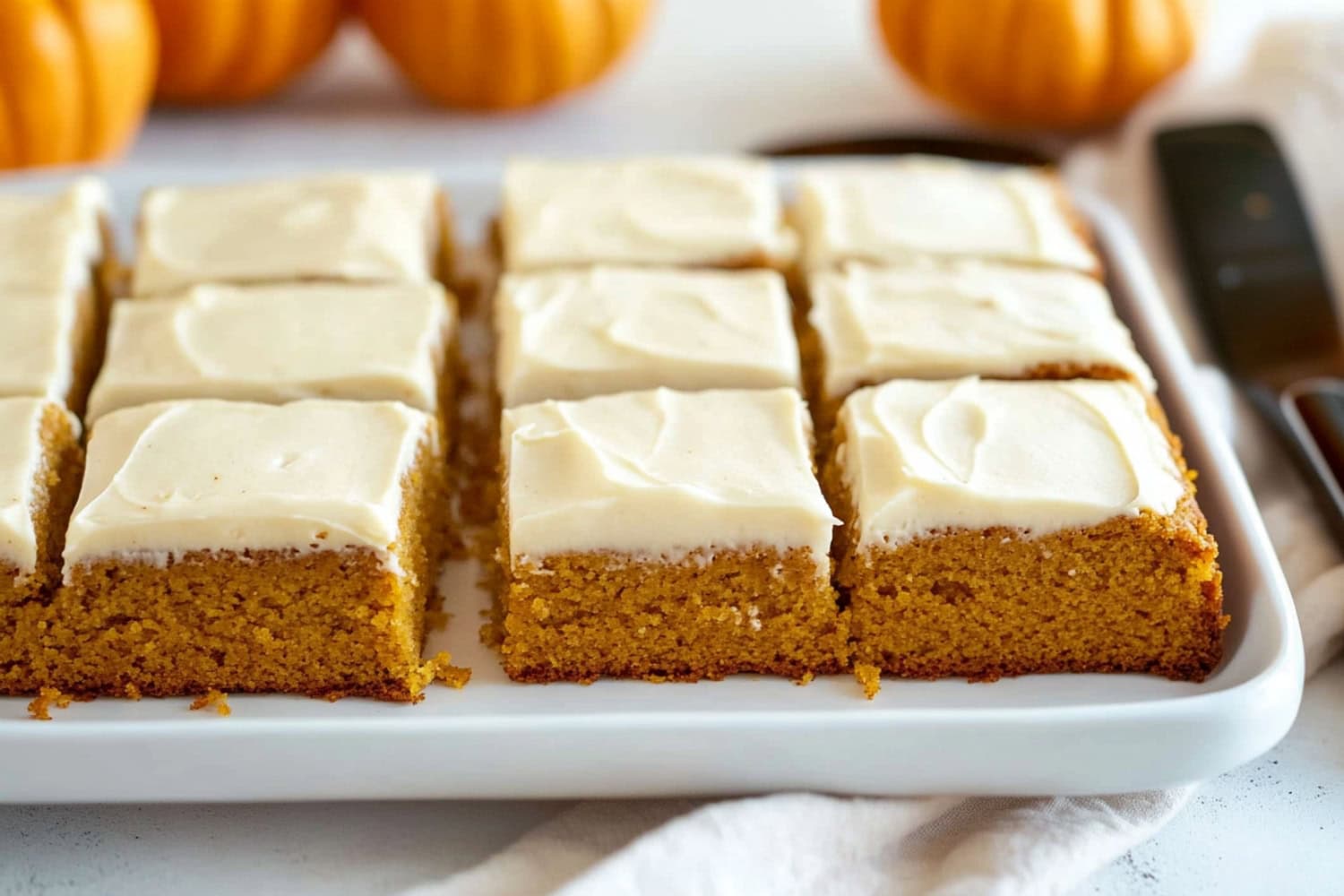 Soft and fluffy homemade pumpkin cake with cream cheese frosting in a baking dish.