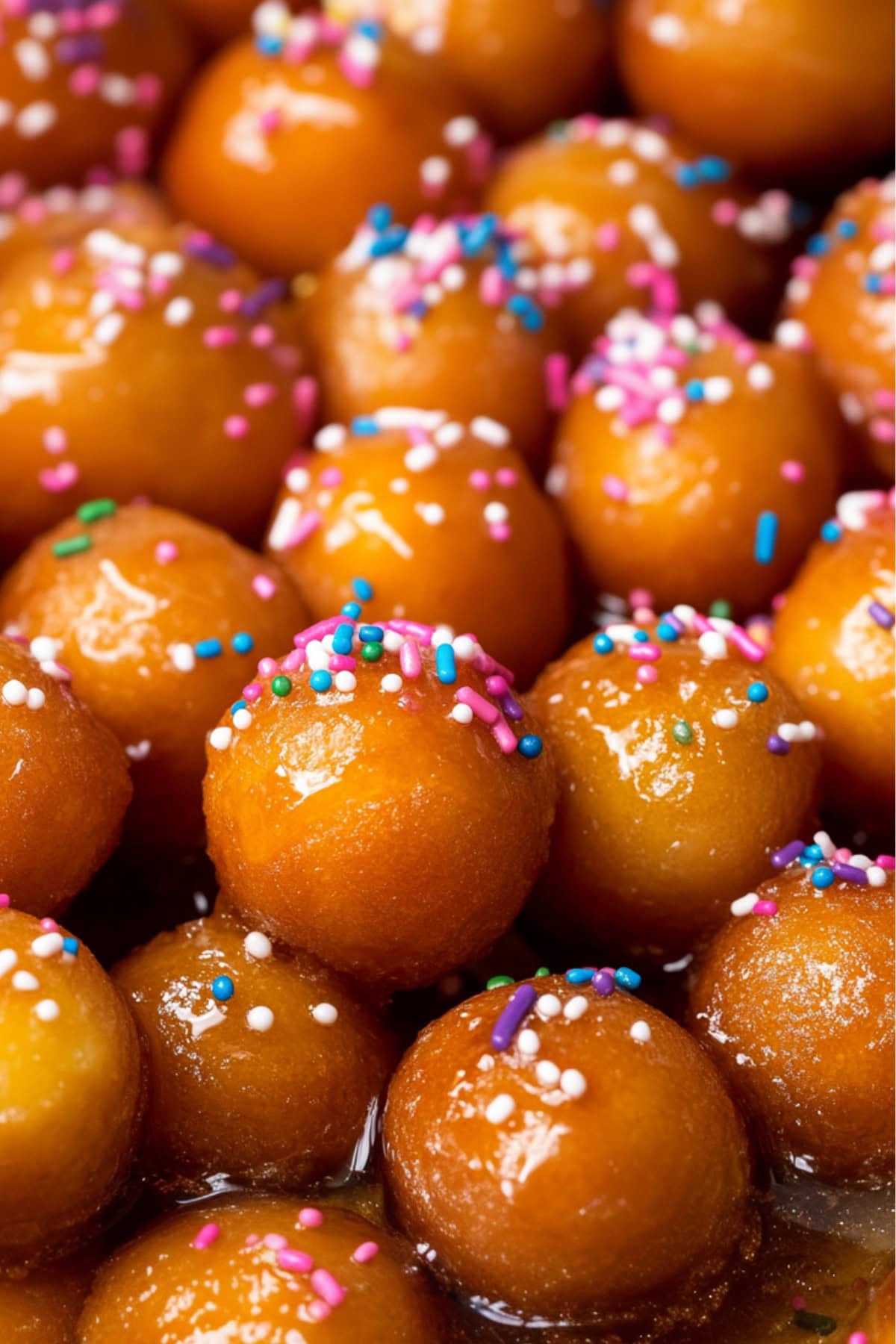 Sweet and sticky honey-coated fried dough balls with sprinkles, close-up