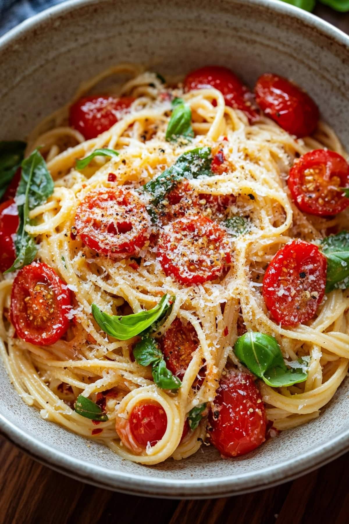 A bowl of tomato basil pasta with grated parmesan.