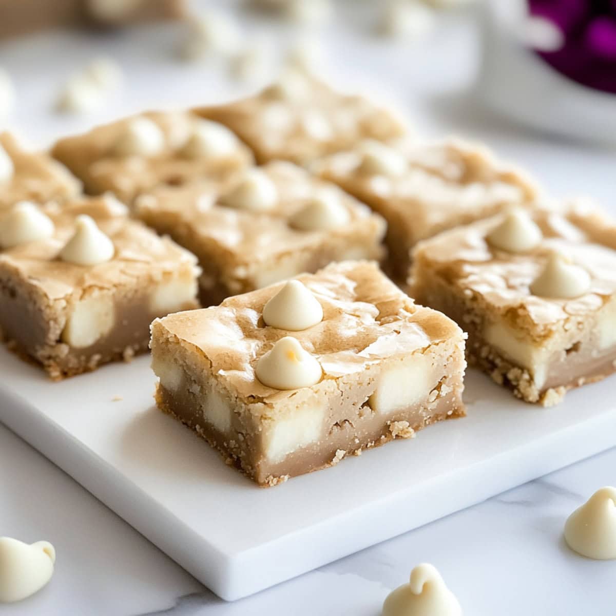 White chocolate brownies sitting on a white board.