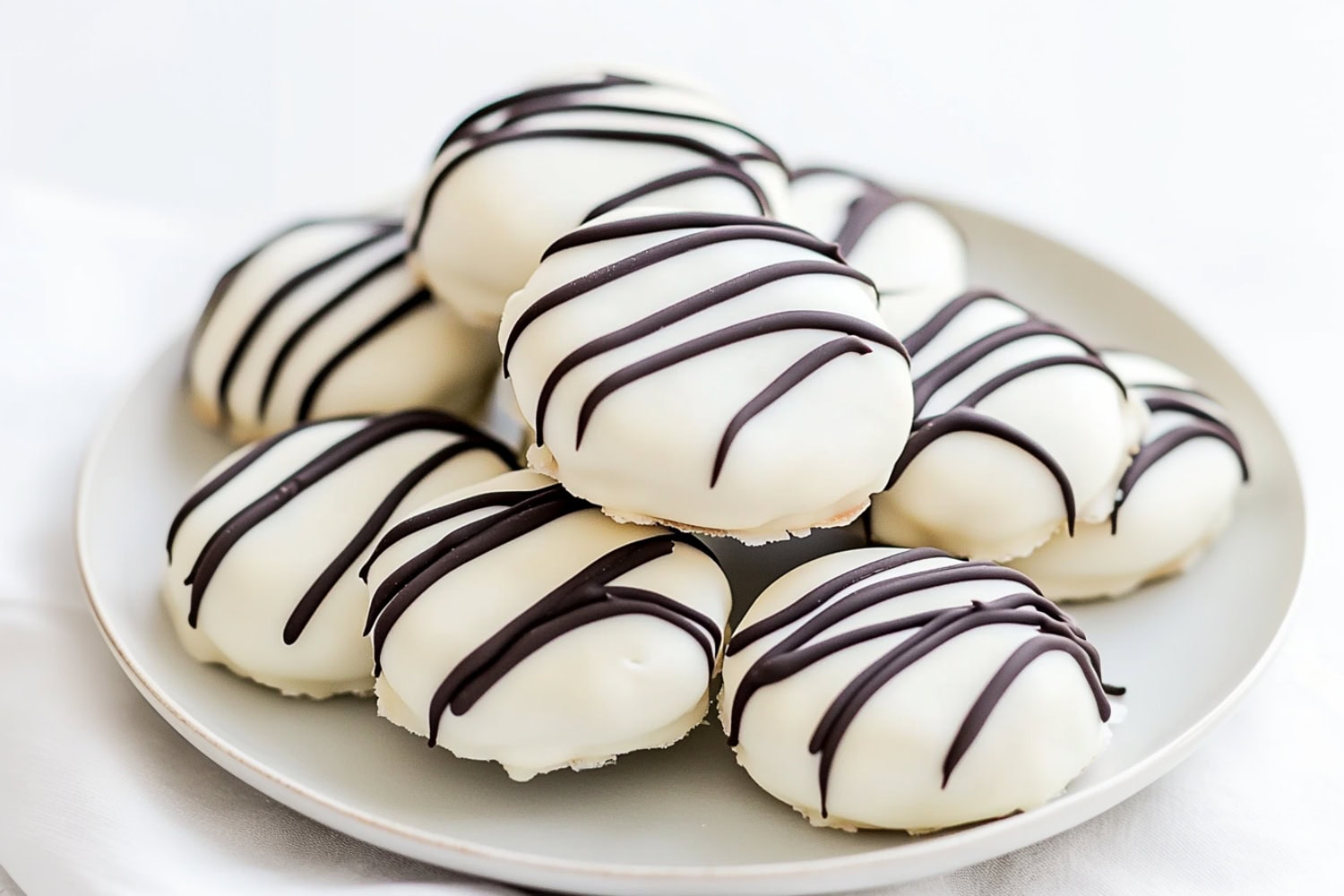 A batch of white chocolate-covered Oreos, each cookie with a thick, creamy white chocolate shell.