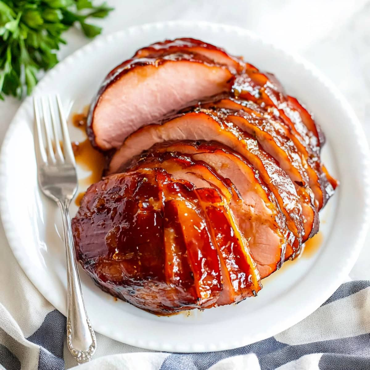 Caramelized maple and mustard glazed roasted ham sliced on a plate