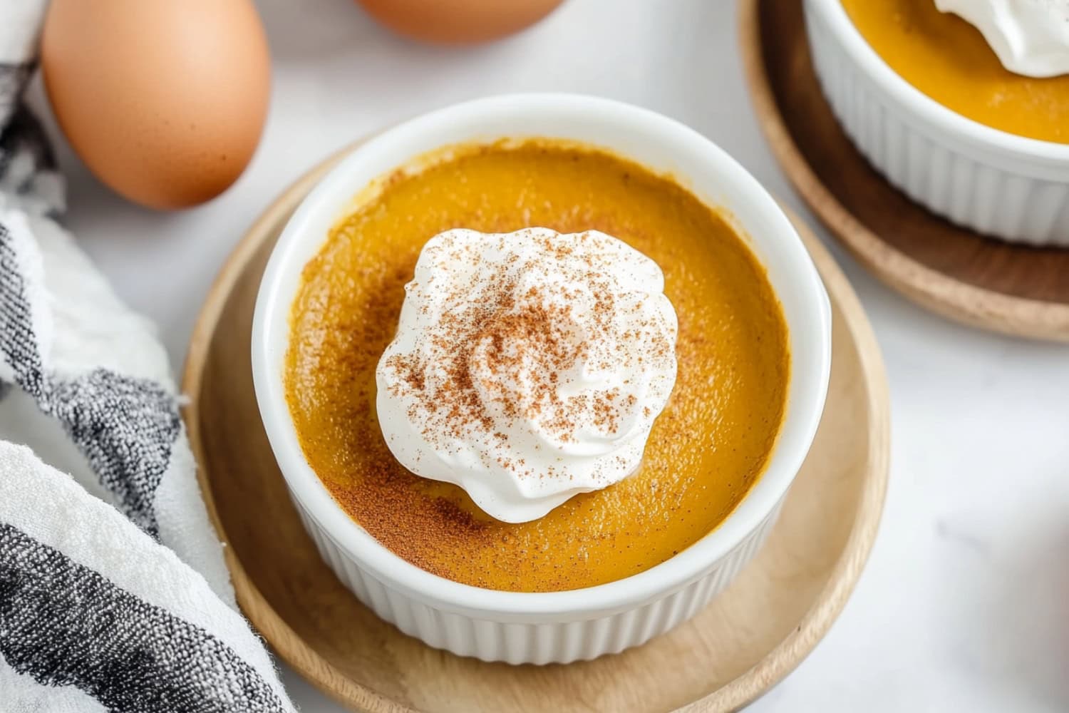 Pumpkin custard topped with a light dusting of cinnamon and a dollop of whipped cream.