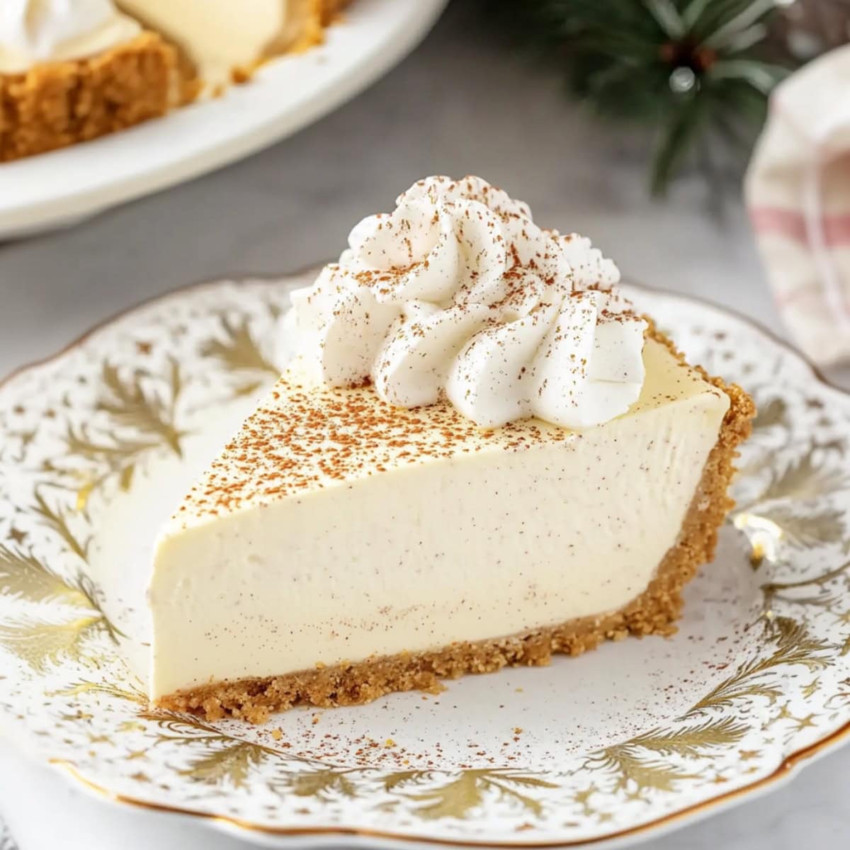 A close-up shot of sliced homemade eggnog cheesecake with whipped cream topping.