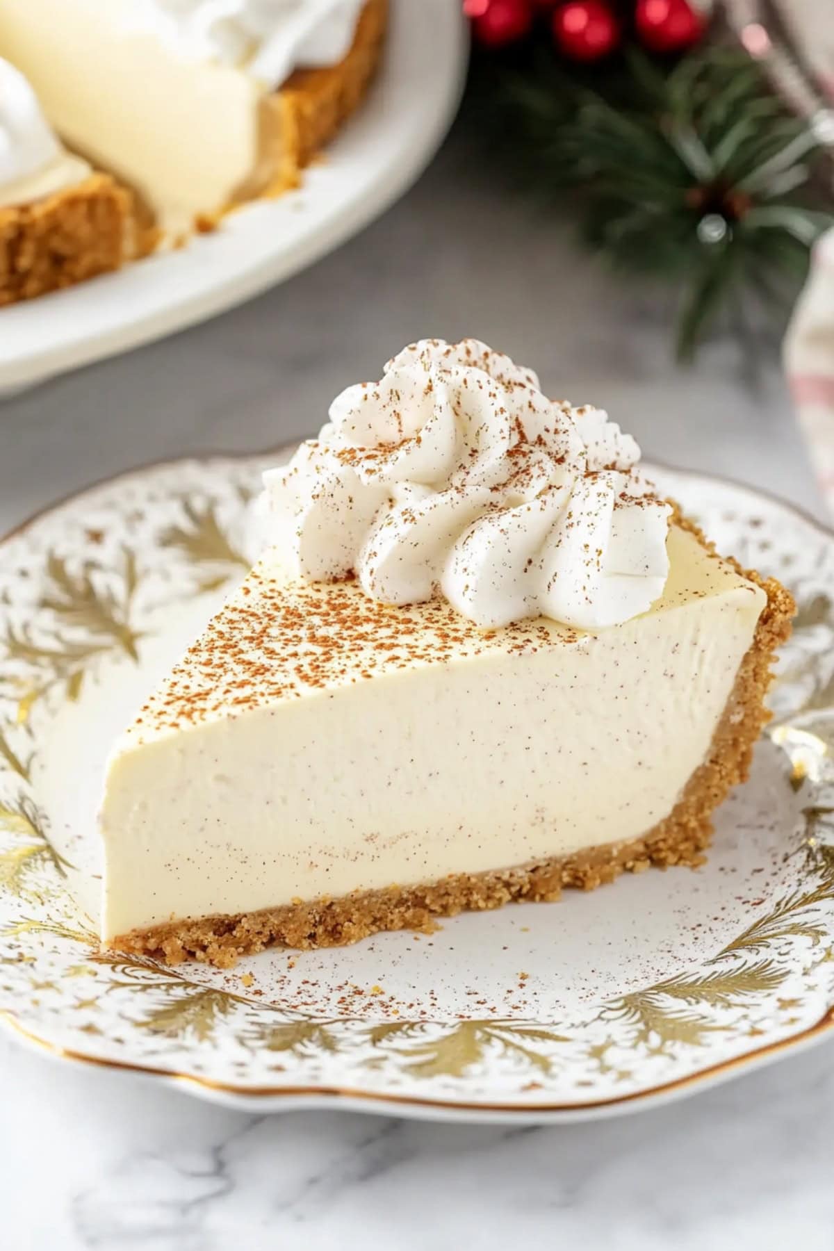 Sliced eggnog cheesecake topped with whipped cream and ground cinnamon.